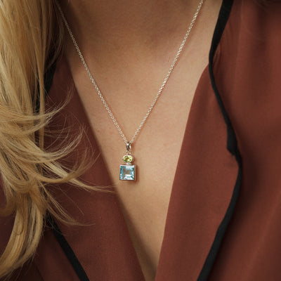 Model Wearing Silver Pendant with Blue Topaz and Peridot